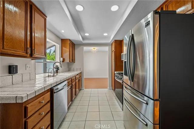 a kitchen with stainless steel appliances granite countertop a refrigerator and a sink