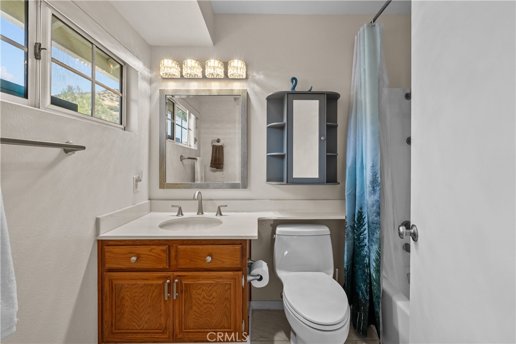 28501 Victoria Road Castaic, CA 91384 - Photo 19 of 45 a bathroom with a toilet a sink and mirror