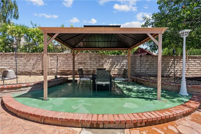 a view of patio with table and chairs under an umbrella
