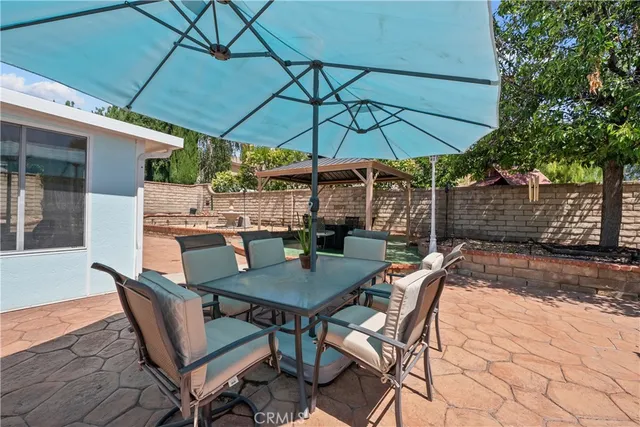 a view of a patio with a table and chairs under an umbrella