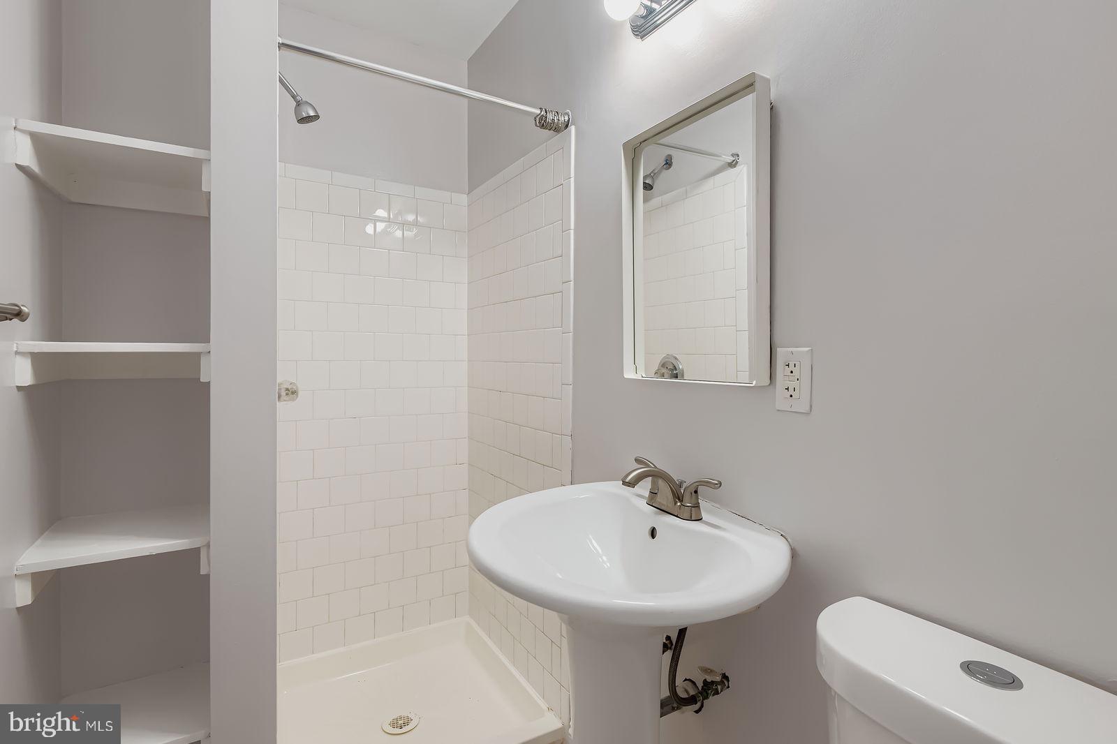 2535 North Howard Street Baltimore, MD 21218 - Photo 7 of 24 a bathroom with a sink a toilet and shower