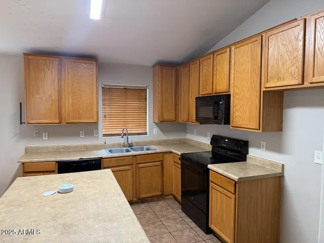 a kitchen with a sink a stove and cabinets