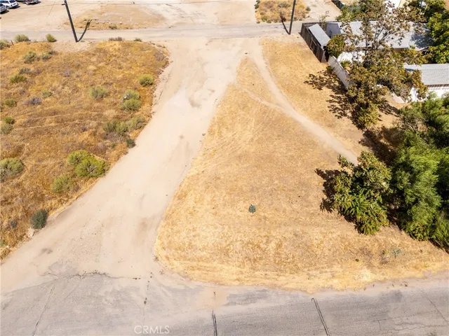an aerial view of a house a yard and mountain view in back