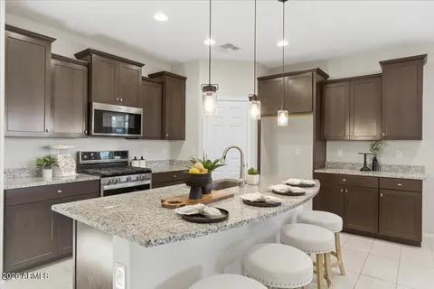 a kitchen with stainless steel appliances granite countertop a sink refrigerator and microwave
