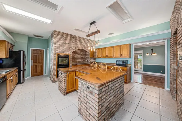 a large spacious kitchen with stainless steel appliances granite countertop a sink and cabinets