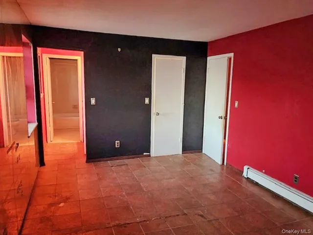 a view of an empty room with closet and a window