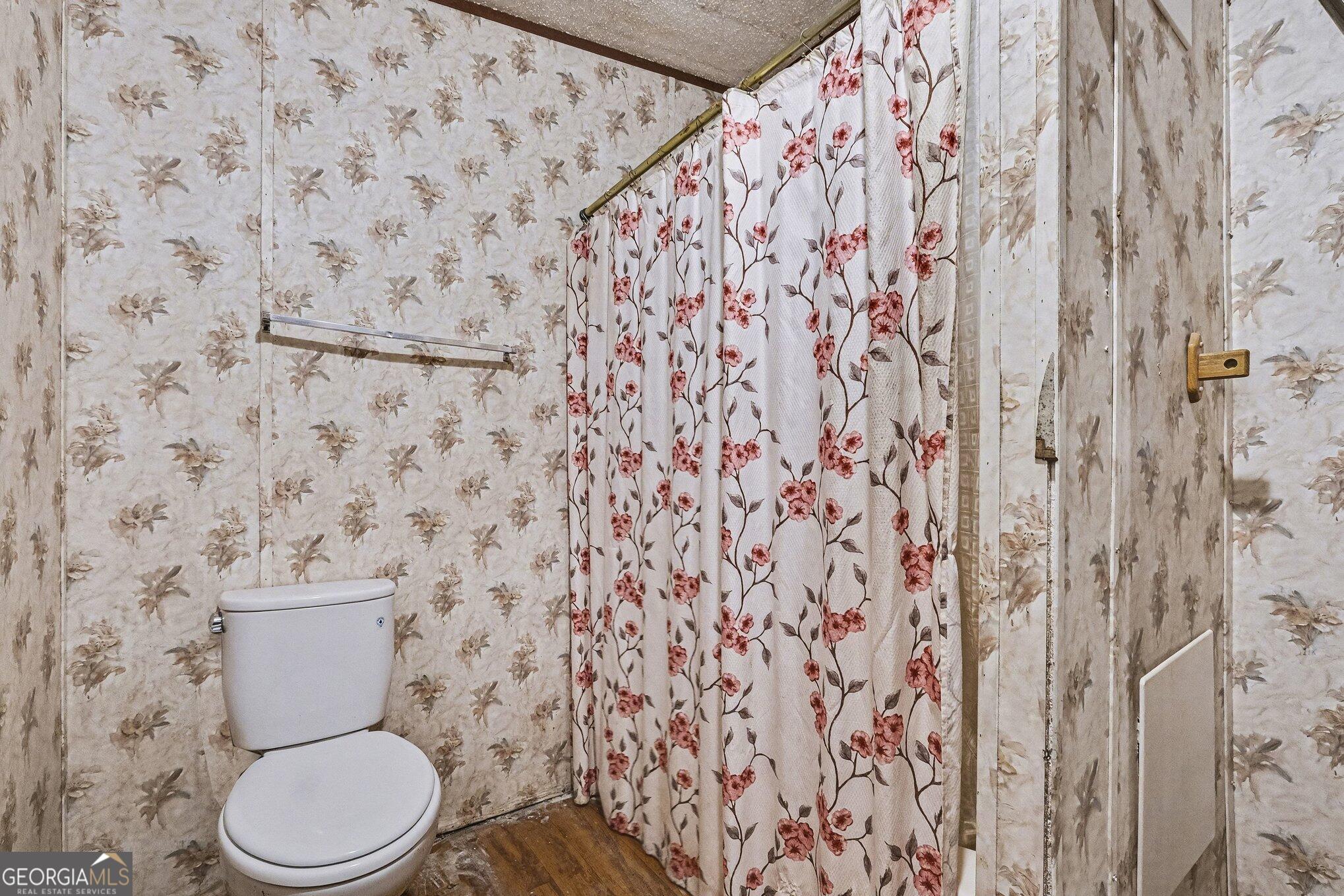 109 Mill Run Comer, GA 30629 - Photo 12 of 23 a white toilet sitting next to a shower curtain
