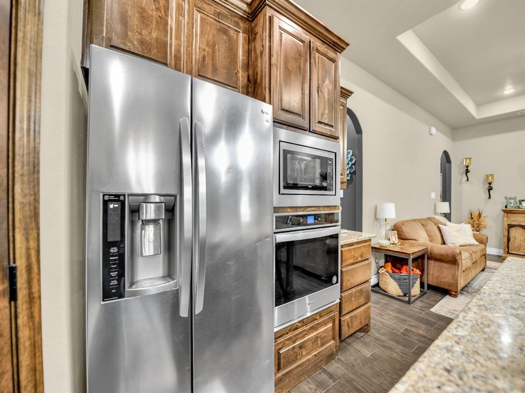 156 Cottongame Road Weatherford, TX 76088 - Photo 11 of 35 a kitchen with stainless steel appliances kitchen island granite countertop a refrigerator and a stove