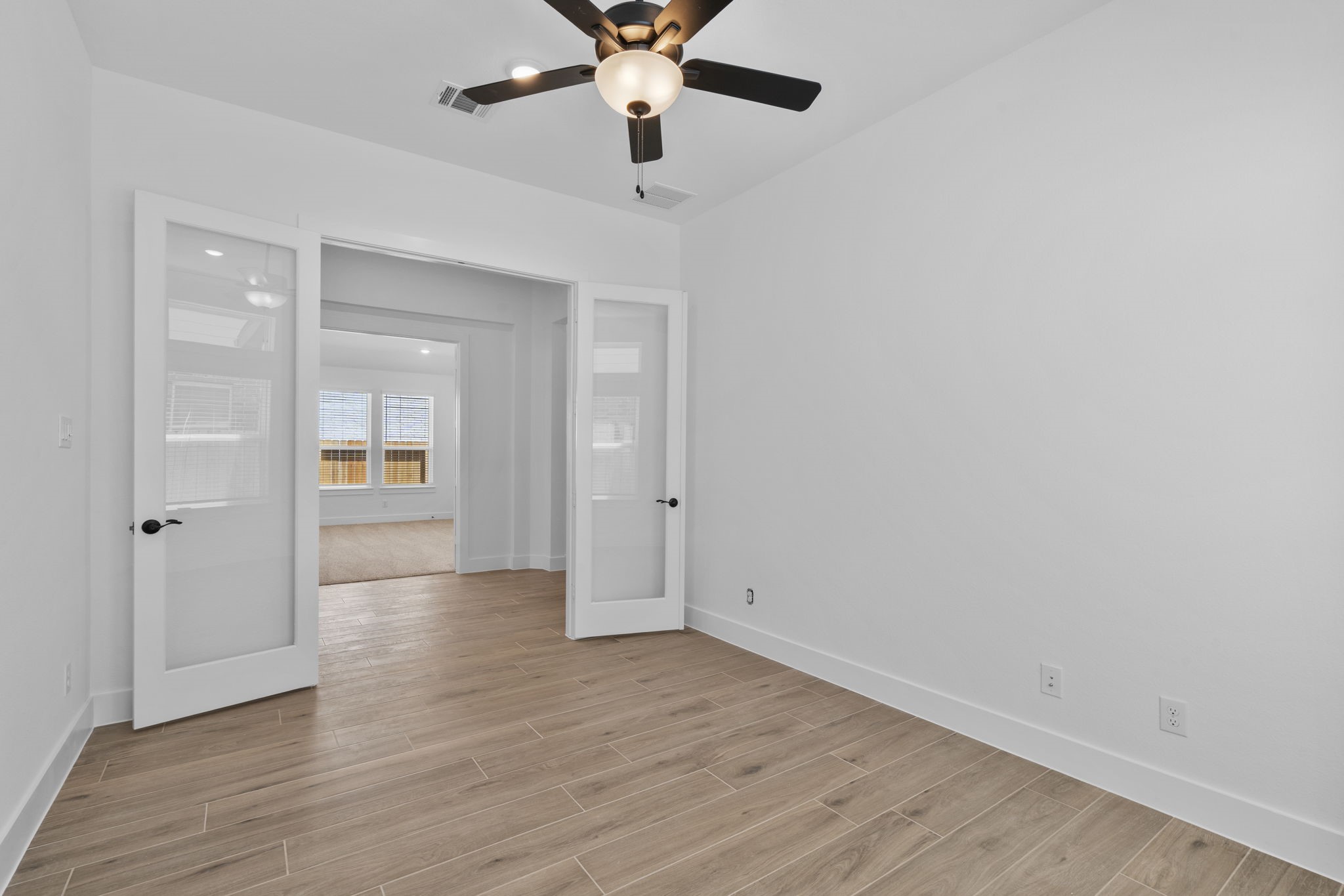 2910 Peach Vly Road Fulshear, TX 77423 - Photo 13 of 35 wooden floor in an empty room with a chandelier fan
