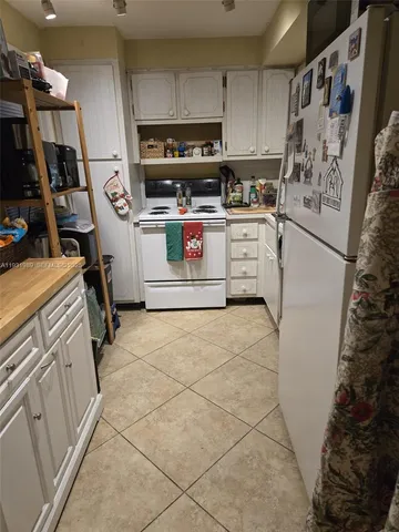 a living room with furniture kitchen view and a wooden floor