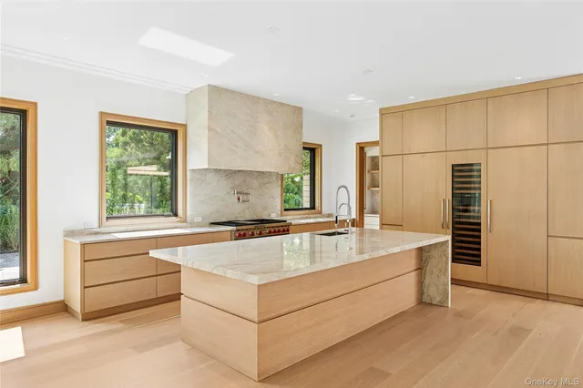 a living room with stainless steel appliances granite countertop a sink and a refrigerator