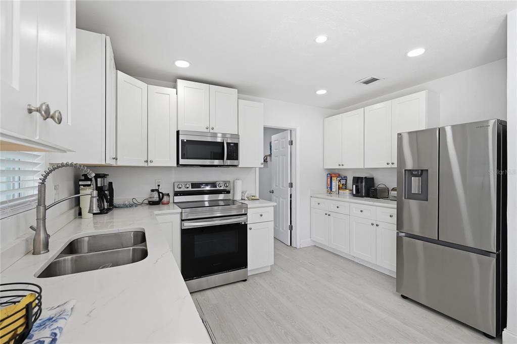 1946 Strathaven Road Winter Park, FL 32792 - Photo 5 of 37 a kitchen with a refrigerator a stove top oven a sink and cabinets