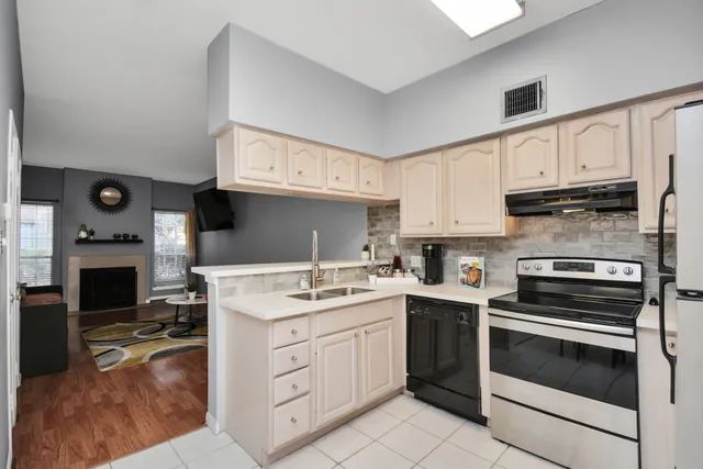 a living room with stainless steel appliances kitchen island granite countertop a refrigerator sink and cabinets