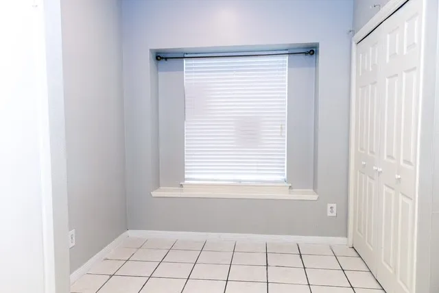 a view of an empty room with window and cabinet