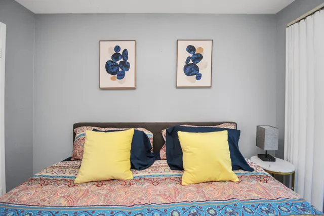 a bedroom with two beds and painting on the wall