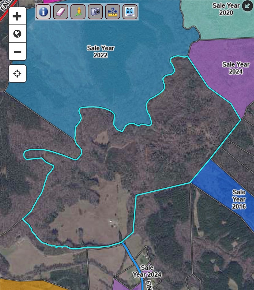 This expansive aerial view showcases a diverse land parcel with significant waterfront and surrounding natural beauty.
