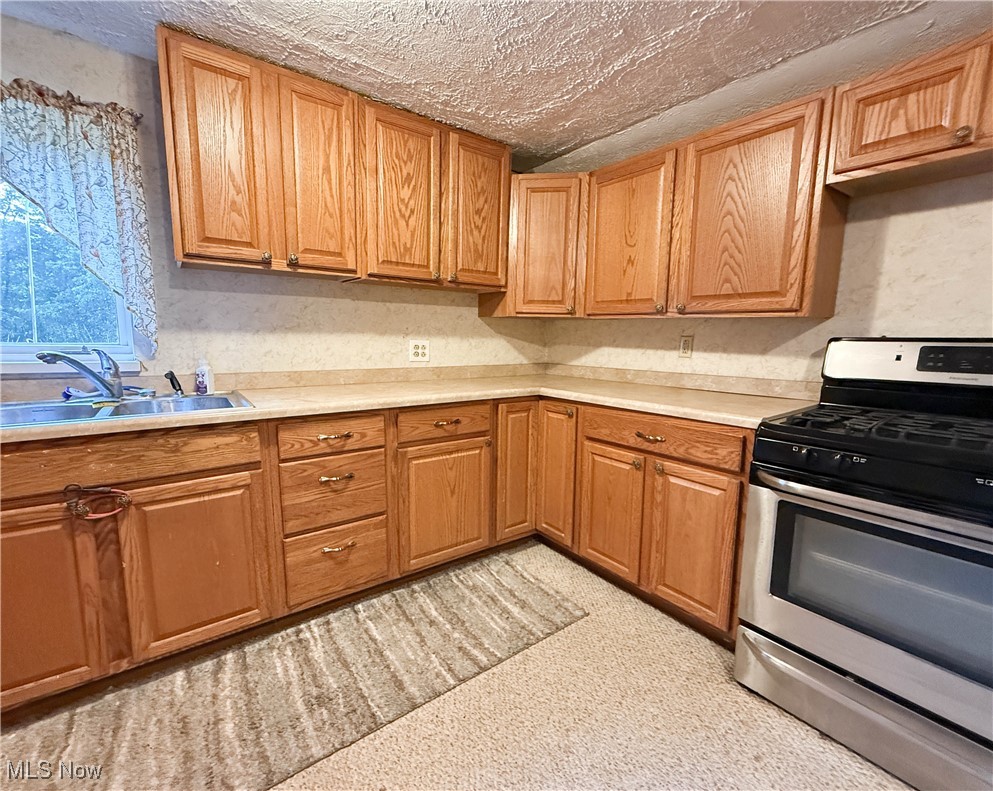 8756 Cook Road Salem, OH 44460 - Photo 12 of 50 Kitchen featuring gas stove, light countertops, and a textured ceiling