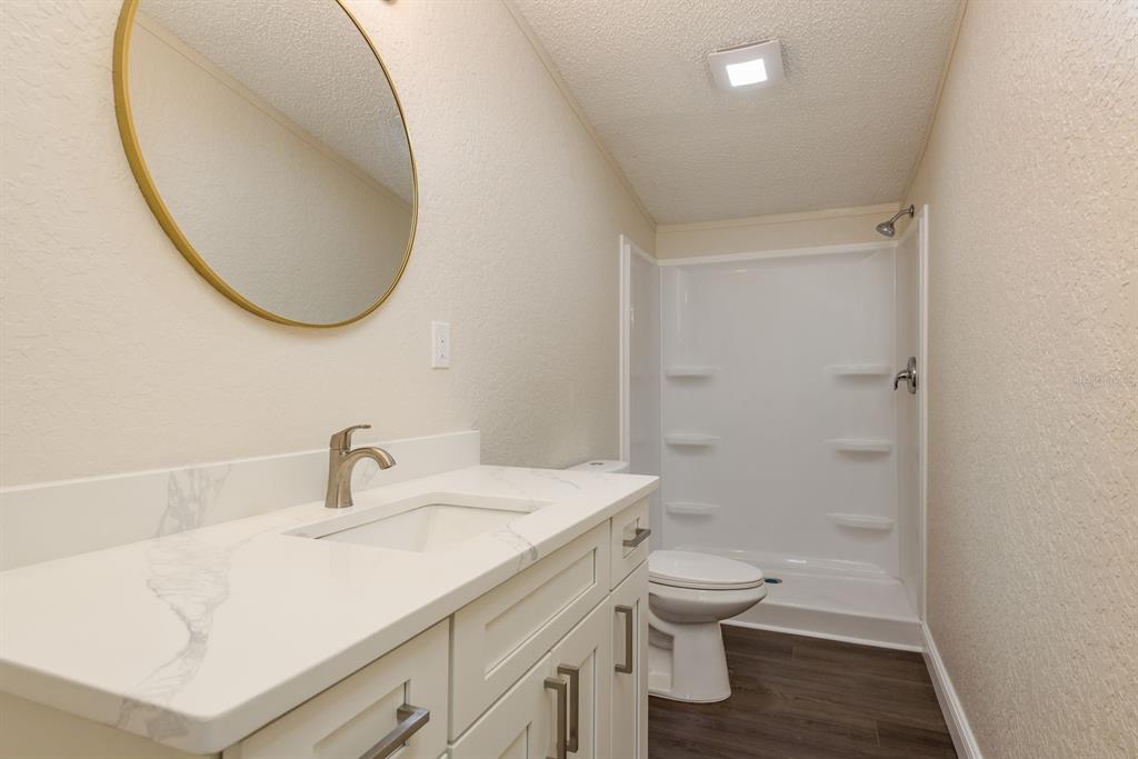 6707 Celeste Lane New Port Richey, FL 34653 - Photo 13 of 21 a bathroom with a sink a toilet and a mirror