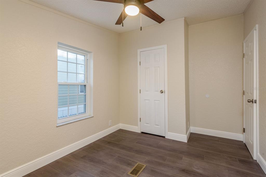 6707 Celeste Lane New Port Richey, FL 34653 - Photo 15 of 21 an empty room with wooden floor chandelier fan and windows