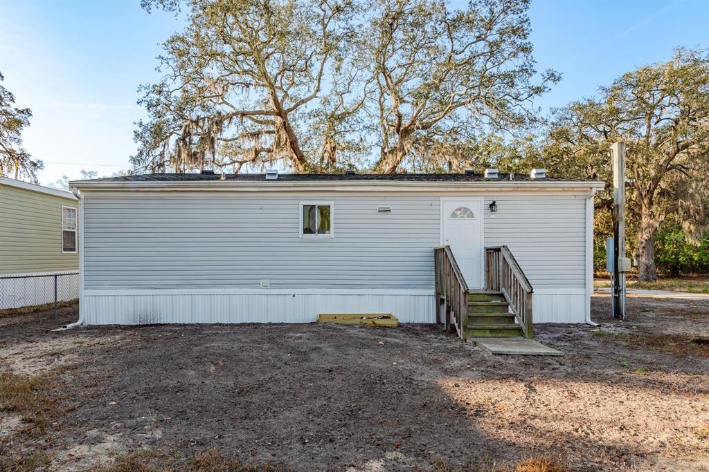 6707 Celeste Lane New Port Richey, FL 34653 - Photo 20 of 21 a view of a barn in the backyard with large tree