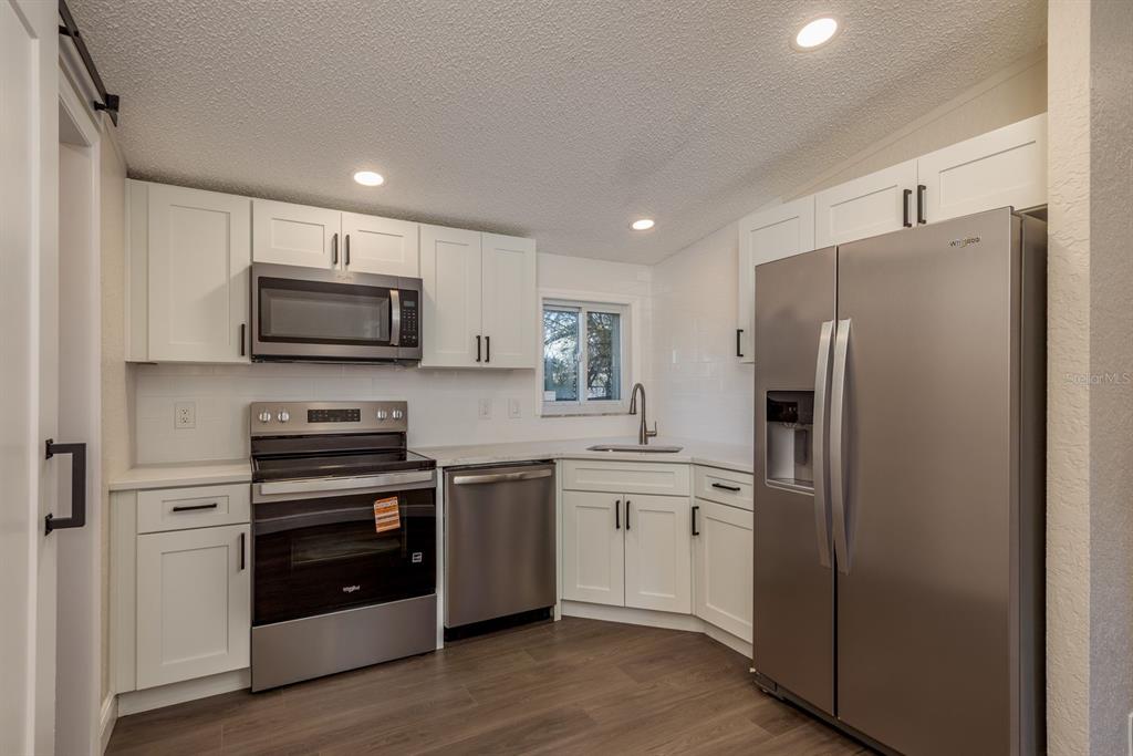 6707 Celeste Lane New Port Richey, FL 34653 - Photo 8 of 21 a kitchen with stainless steel appliances a refrigerator stove and sink