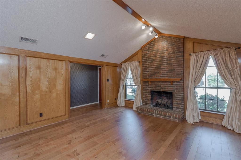 1106 Derby Run Carrollton, TX 75007 - Photo 3 of 26 an empty room with wooden floor fireplace and windows