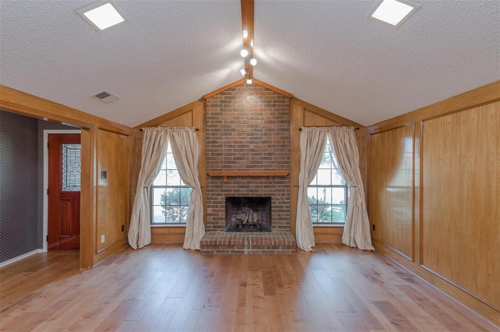 1106 Derby Run Carrollton, TX 75007 - Photo 6 of 26 an empty room with wooden floor fireplace and windows
