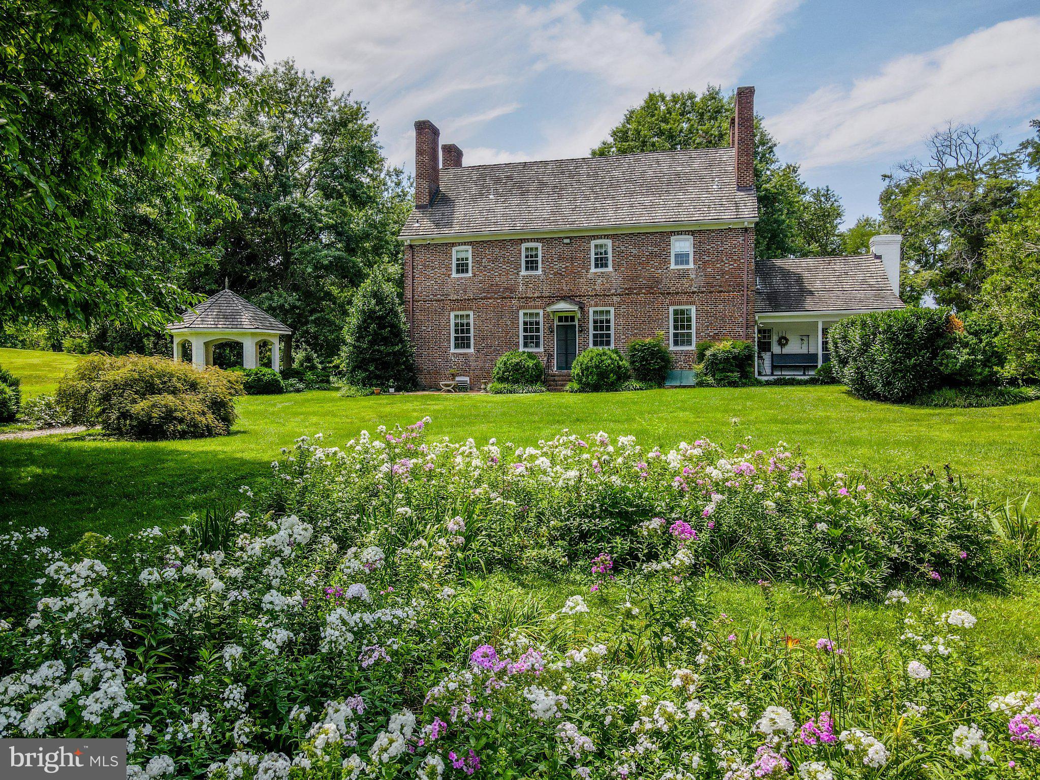 Charming brick home amid blooming gardens.