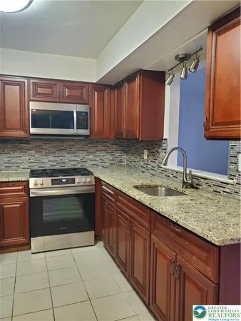 a kitchen with stainless steel appliances granite countertop a stove sink and cabinets