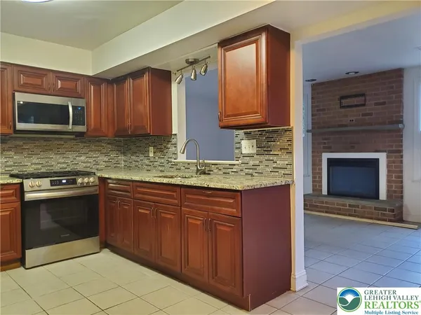 a kitchen with stainless steel appliances granite countertop a stove microwave and cabinets