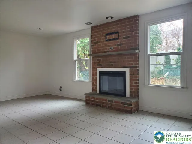 a living room with a fireplace and a window