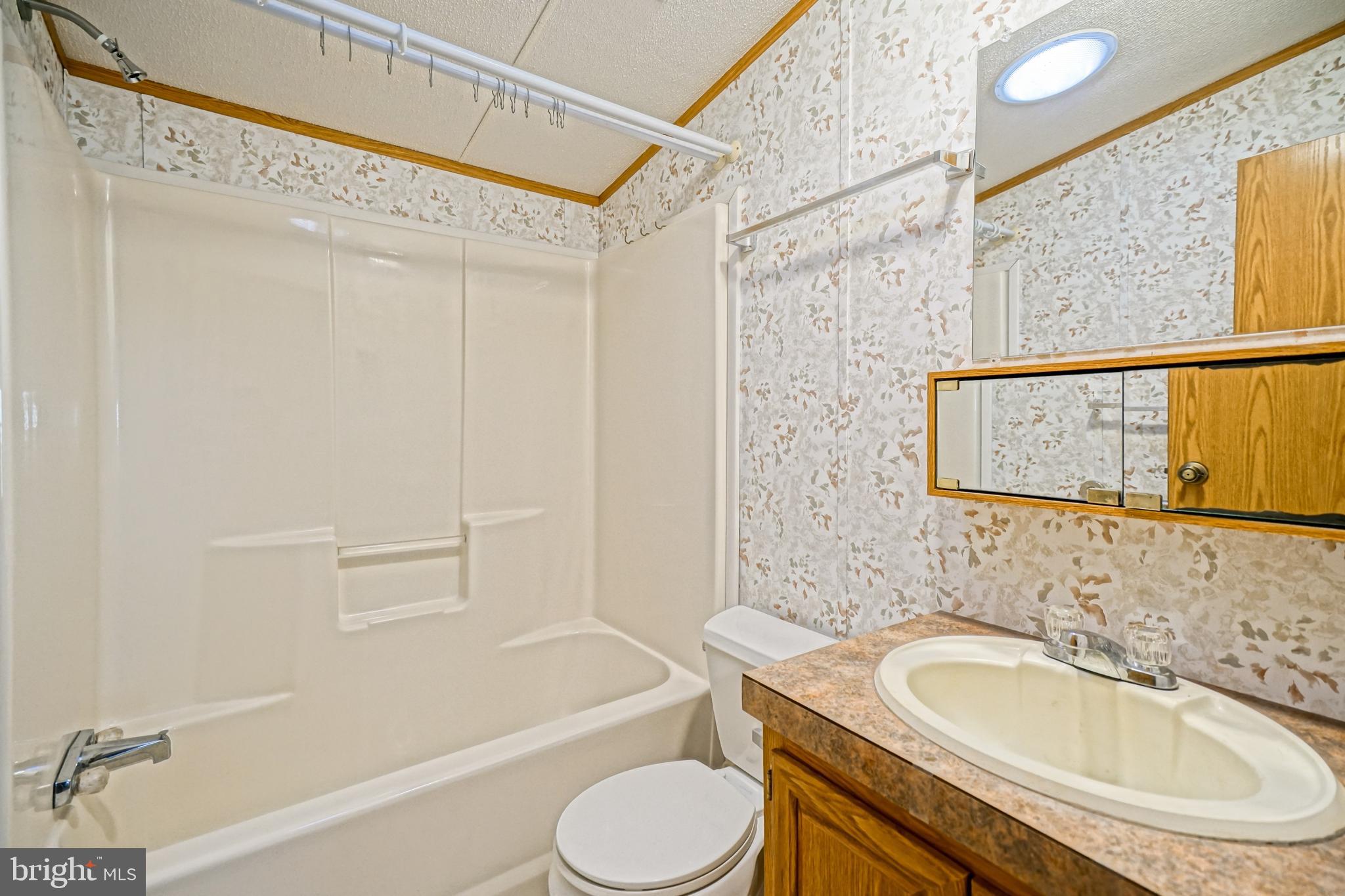 22916 Pine Road Lewes, DE 19958 - Photo 20 of 35 a bathroom with a sink toilet and shower