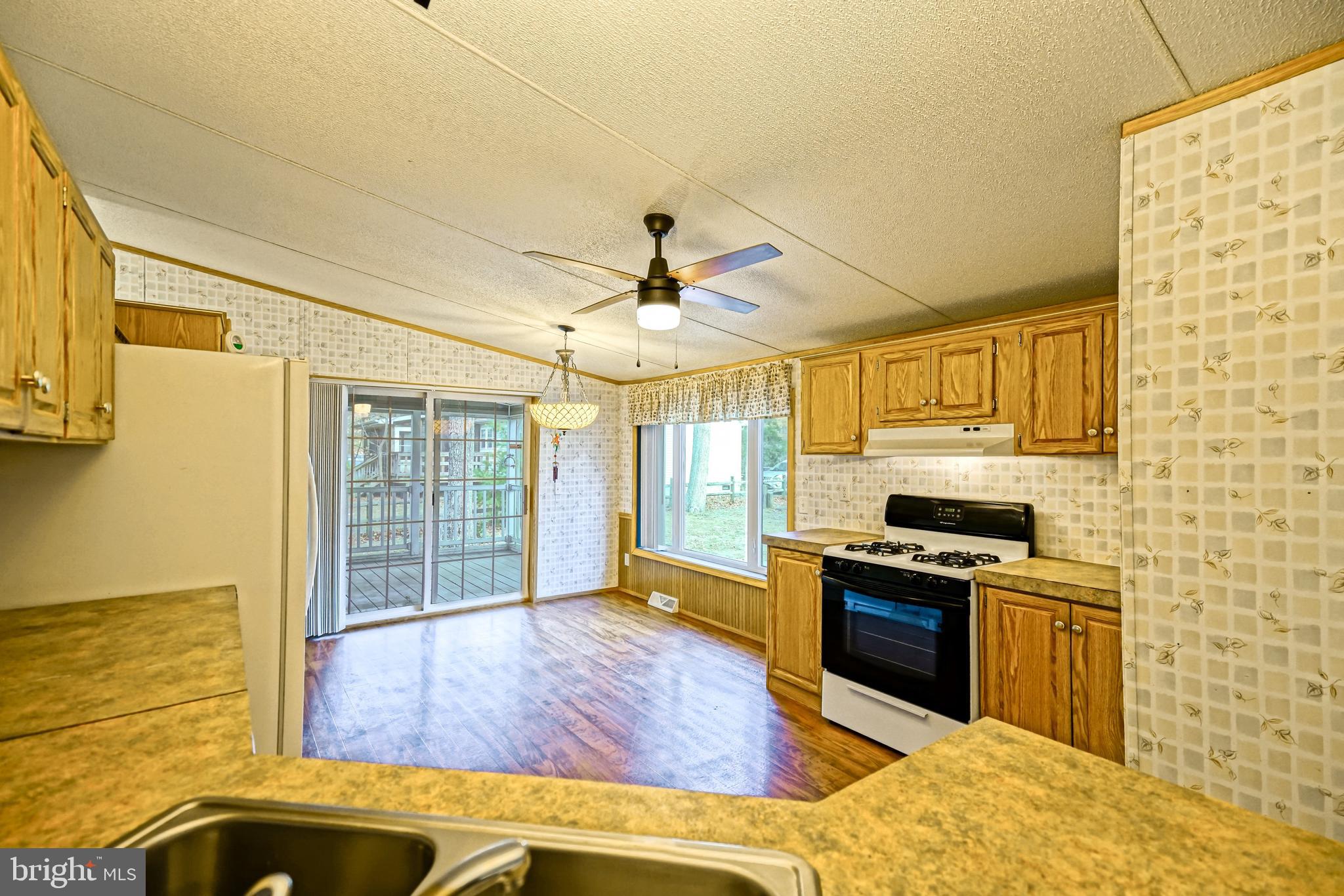 22916 Pine Road Lewes, DE 19958 - Photo 6 of 35 a kitchen with wooden floor and stainless steel appliances