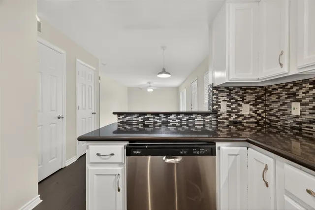 a kitchen with granite countertop a sink dishwasher a stove and a refrigerator