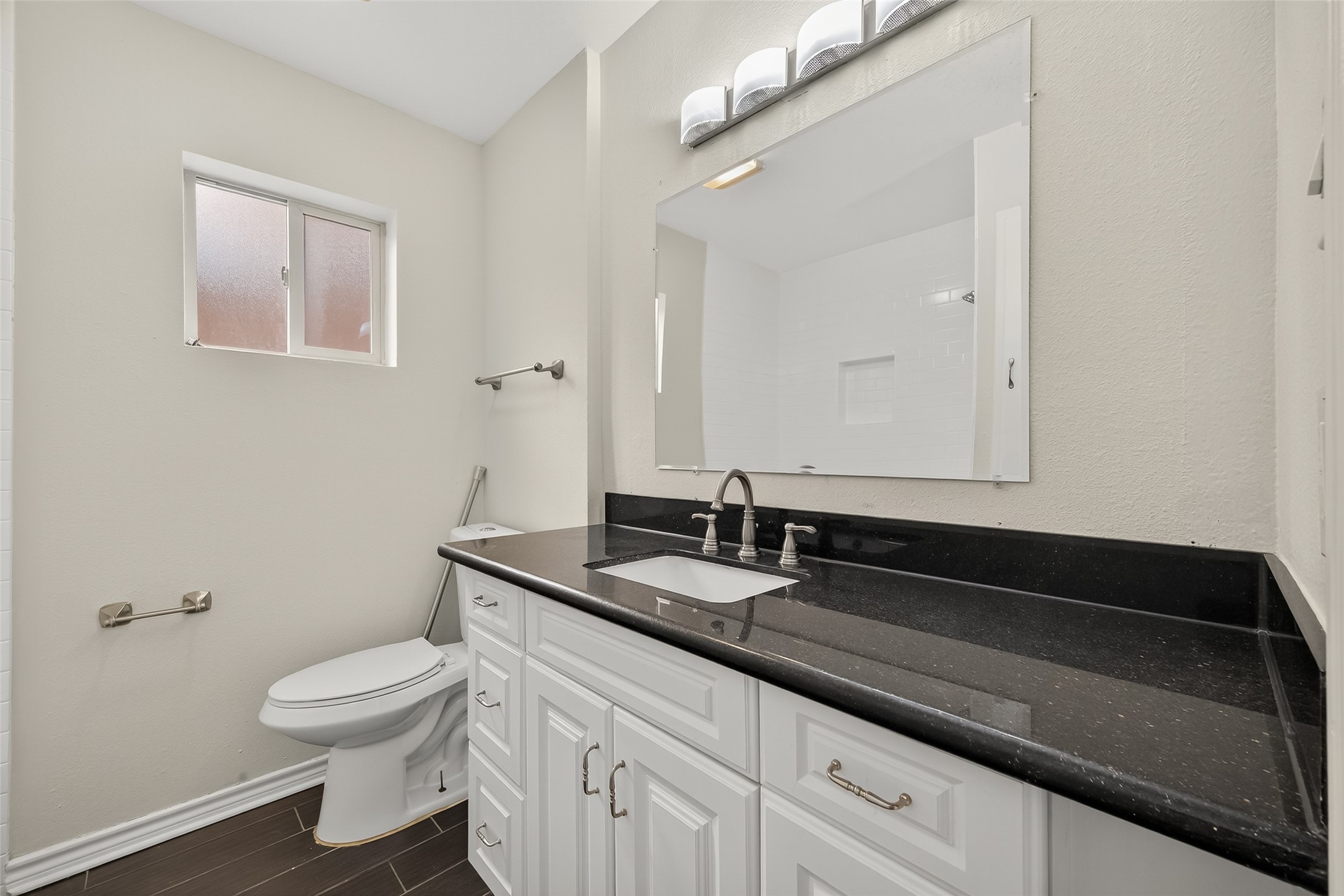 2020 Huldy Street, Unit 2 Houston, TX 77019 - Photo 28 of 34 a bathroom with a granite countertop sink a toilet and a mirror