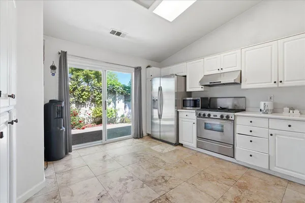 a kitchen with stainless steel appliances granite countertop a refrigerator sink and stove