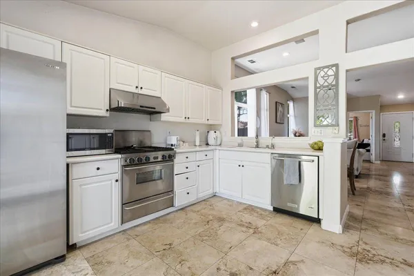 a kitchen with white cabinets and white appliances