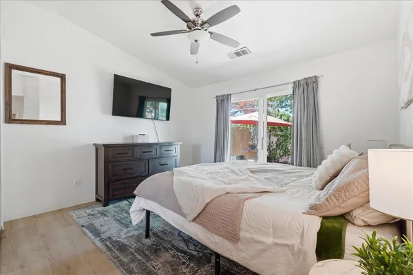 a bedroom with a bed a flat screen tv and a window