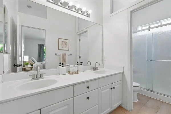 a bathroom with double sink and a mirror