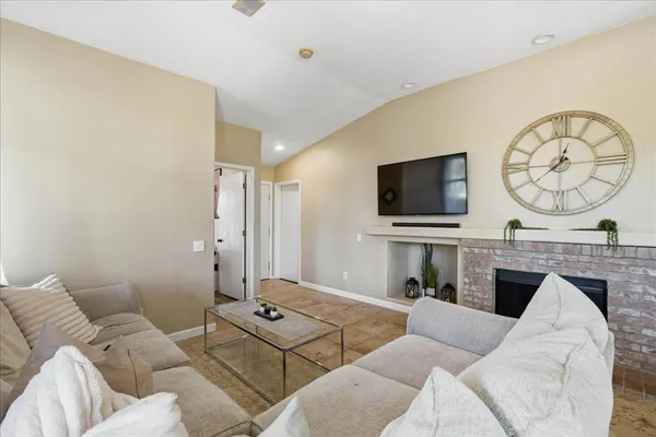 a living room with furniture a flat screen tv and a wall clock