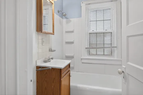 a bathroom with a sink vanity tub and a shower