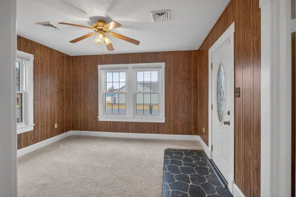 a view of a hallway with a chandelier fan and windows