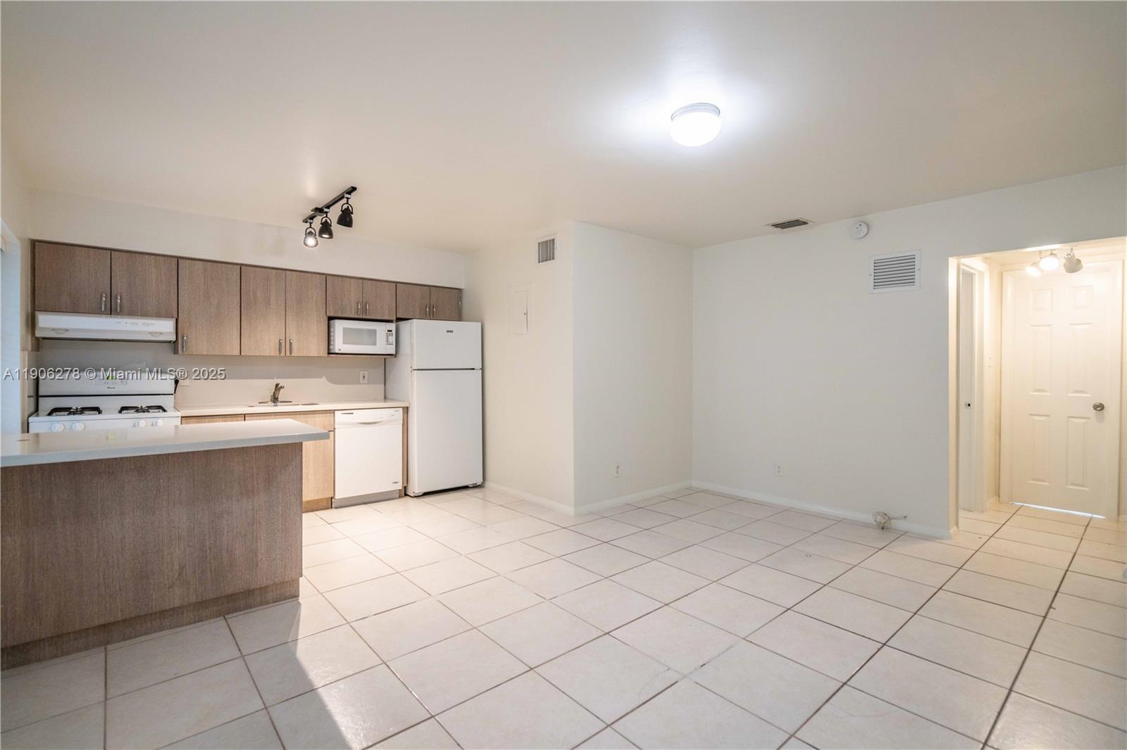 666 Northeast 80th Street, Unit 9 Miami, FL 33138 - Photo 4 of 16 a kitchen with cabinets and white appliances