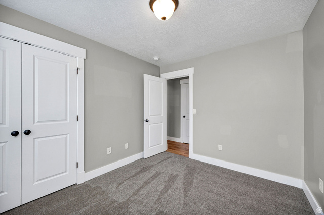 2912 South 1080th Street West Logan, UT 84321 - Photo 6 of 43 Neutral tone wall finish, white baseboard trim, and grey carpet flooring
