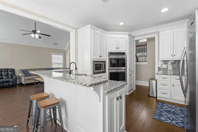 a kitchen with white cabinets and oven