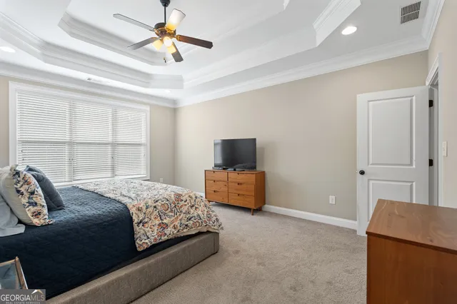 a bedroom with a large bed and a flat tv screen on a dresser