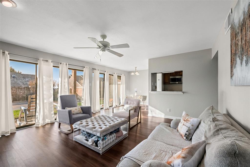 Living area featuring wood finished floors, ceiling fan, and a chandelier