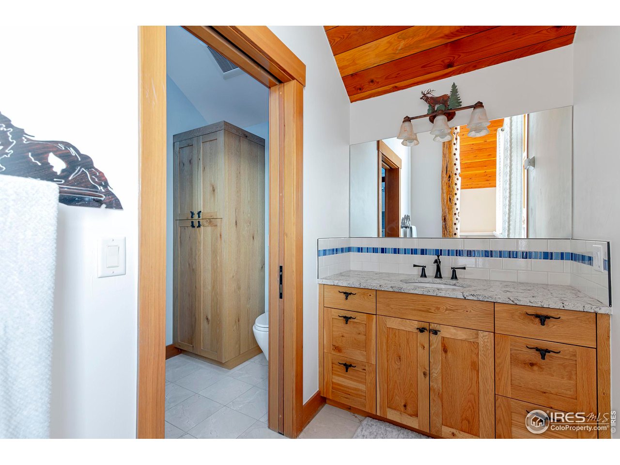 8642 Mineral Road Longmont, CO 80503 - Photo 24 of 50 a bathroom with a granite countertop sink a mirror and a