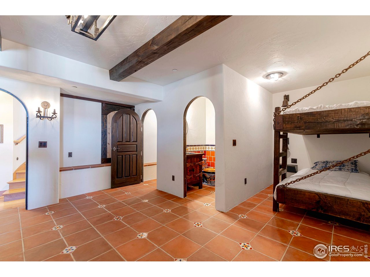 8642 Mineral Road Longmont, CO 80503 - Photo 35 of 50 a bedroom with a bed and a chandelier