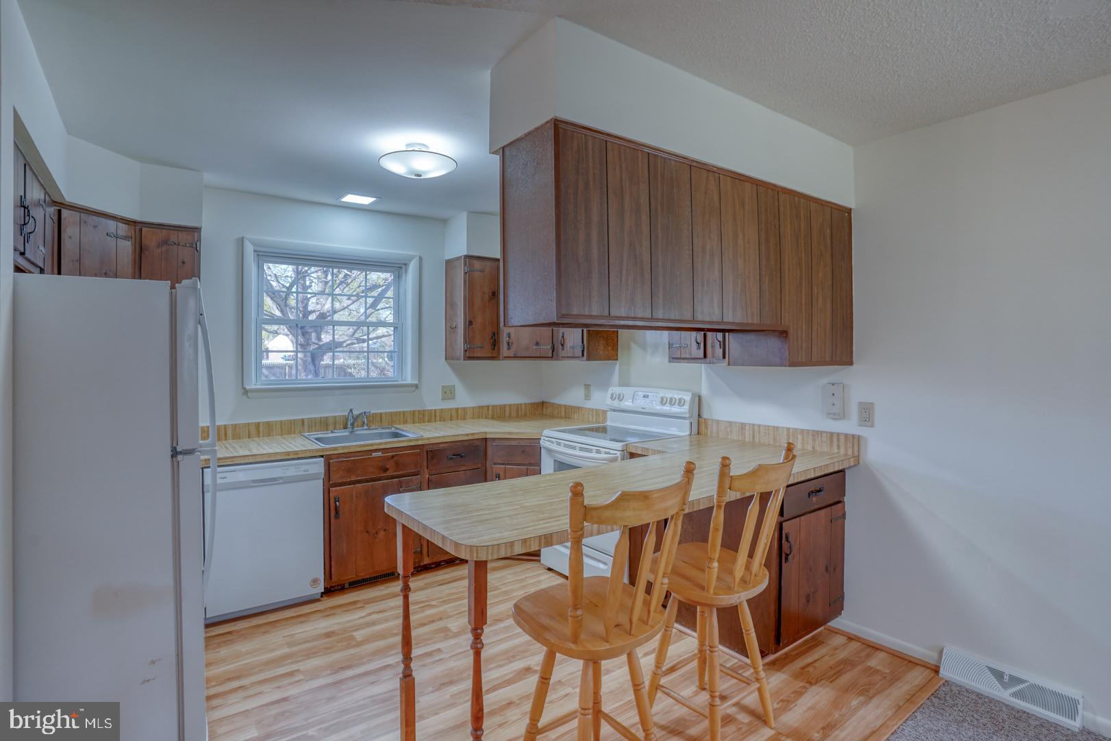 39 Duchess Circle Dover, DE 19901 - Photo 17 of 48 a kitchen with a table chairs refrigerator and wooden cabinets